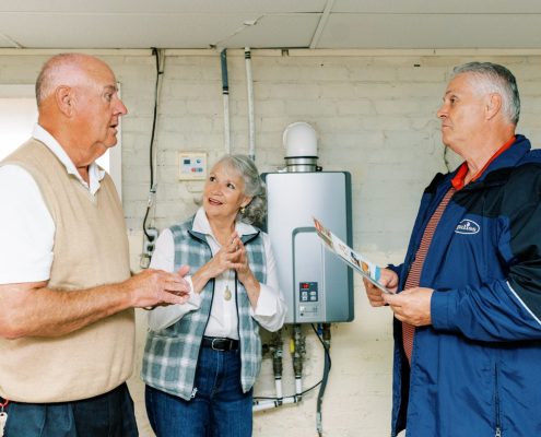 Couple talking with a technician about tankless water heaters.