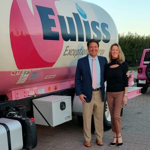 Chris Stanley and wife Dallas in front of pink tank wagon.