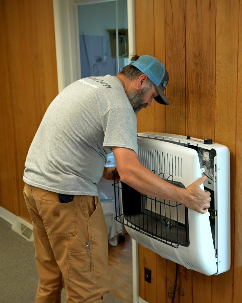Euliss technician installing space heater at a Pleasant Garden Home.