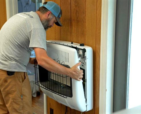 Euliss technician installing a space heater in a Pleasant Garden Home