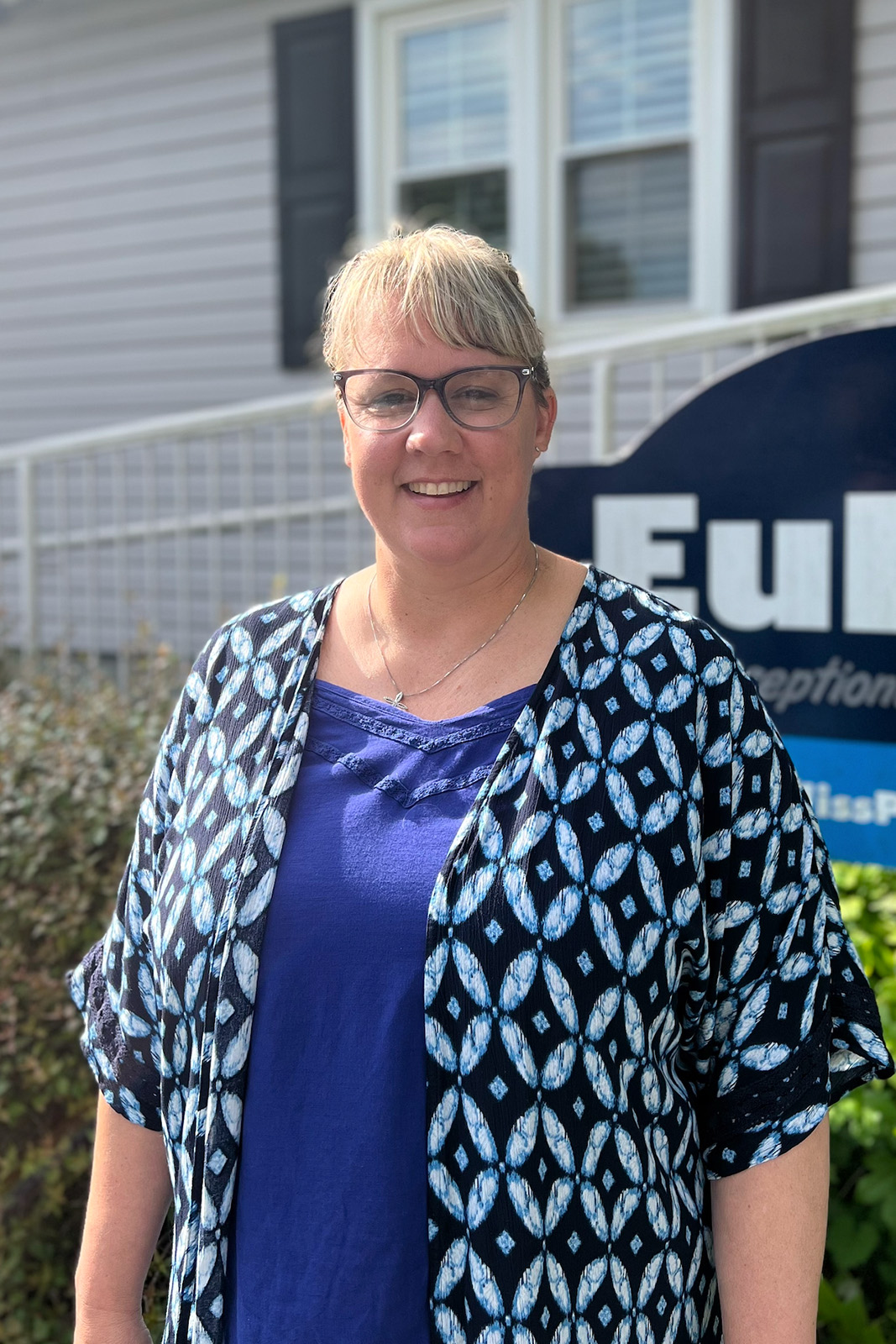 Amy Johnson, Euliss Propane Customer Service Representative, posing for headshot in front of Euliss sign.
