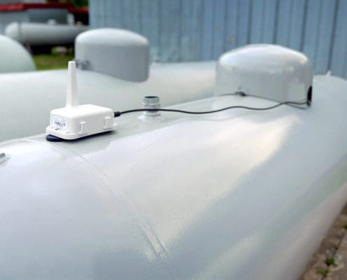 A propane tank with a monitor attatched to the top.