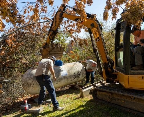 Propane technicians work on a misplaced propane tank after Hurricane Helene.