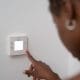 Homeowner adjusting a thermostat to lower their propane ussage.