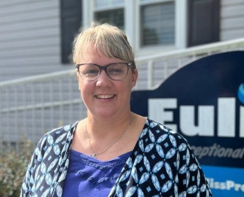 Amy Johnson, Euliss Propane Customer Service Representative, posing for headshot in front of Euliss sign.