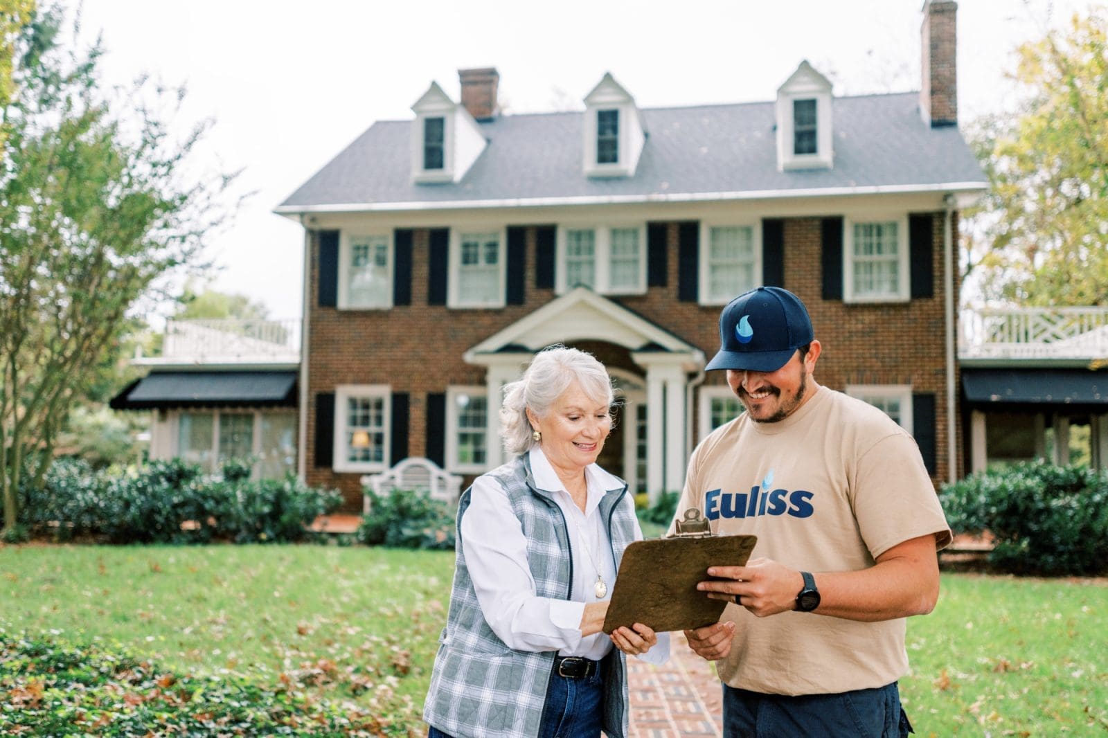 customer and Euliss Propane employee outside of residential home looking down at a clipboard